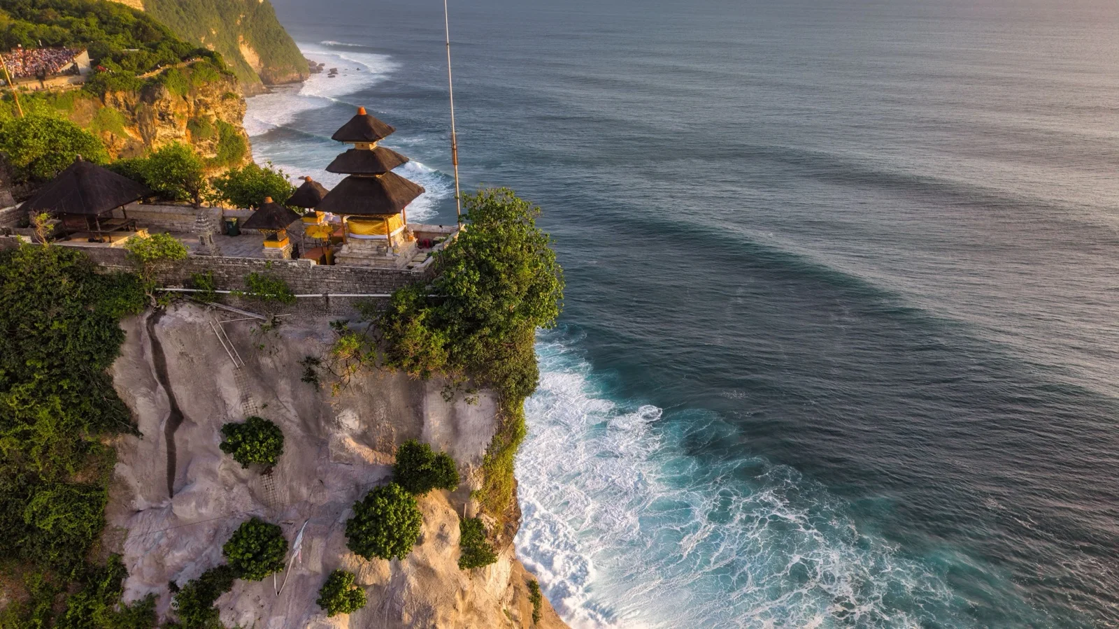 Golden-hour view of Tanah Lot sea temple perched on its rock formation above the Indian Ocean surf