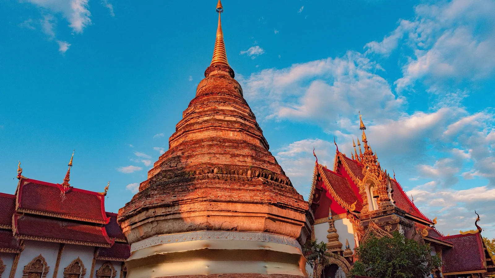 Golden chedi of Wat Phra That Doi Suthep glowing above the Chiang Mai valley at sunset