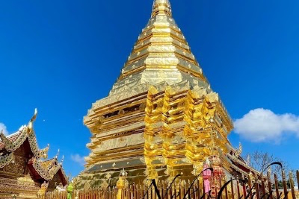 Gilded chedi of Wat Phra That Doi Suthep glowing at sunset above the Chiang Mai valley