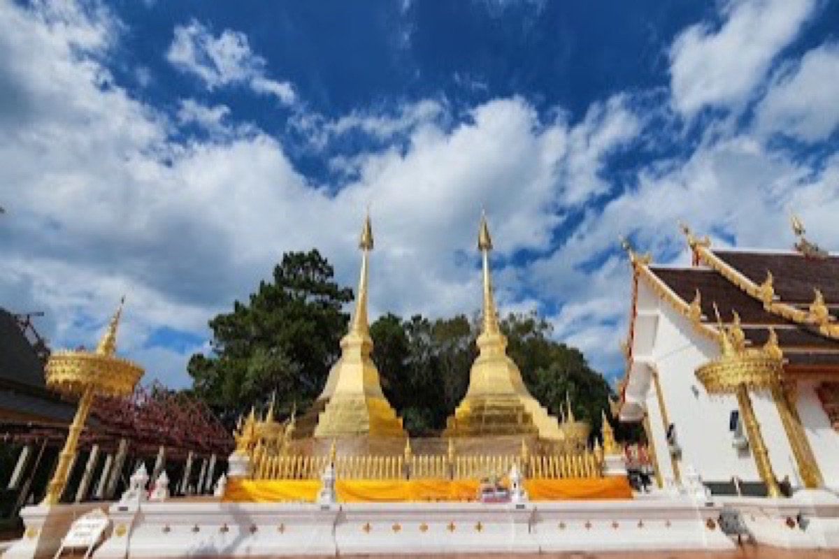 Golden stupa of Phra That Doi Tung rising above morning mist on the mountain near Mae Sai