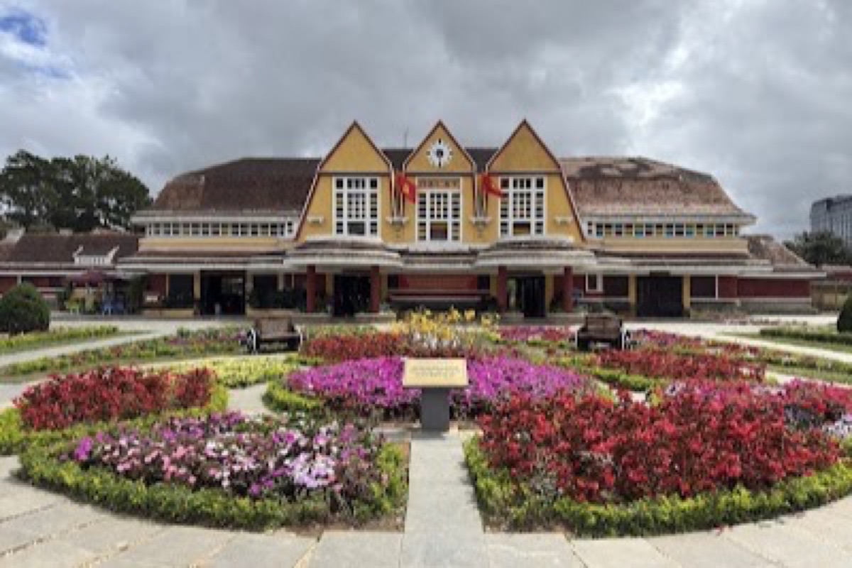 Pastel art-deco facade and vintage locomotive at Da Lat Railway Station