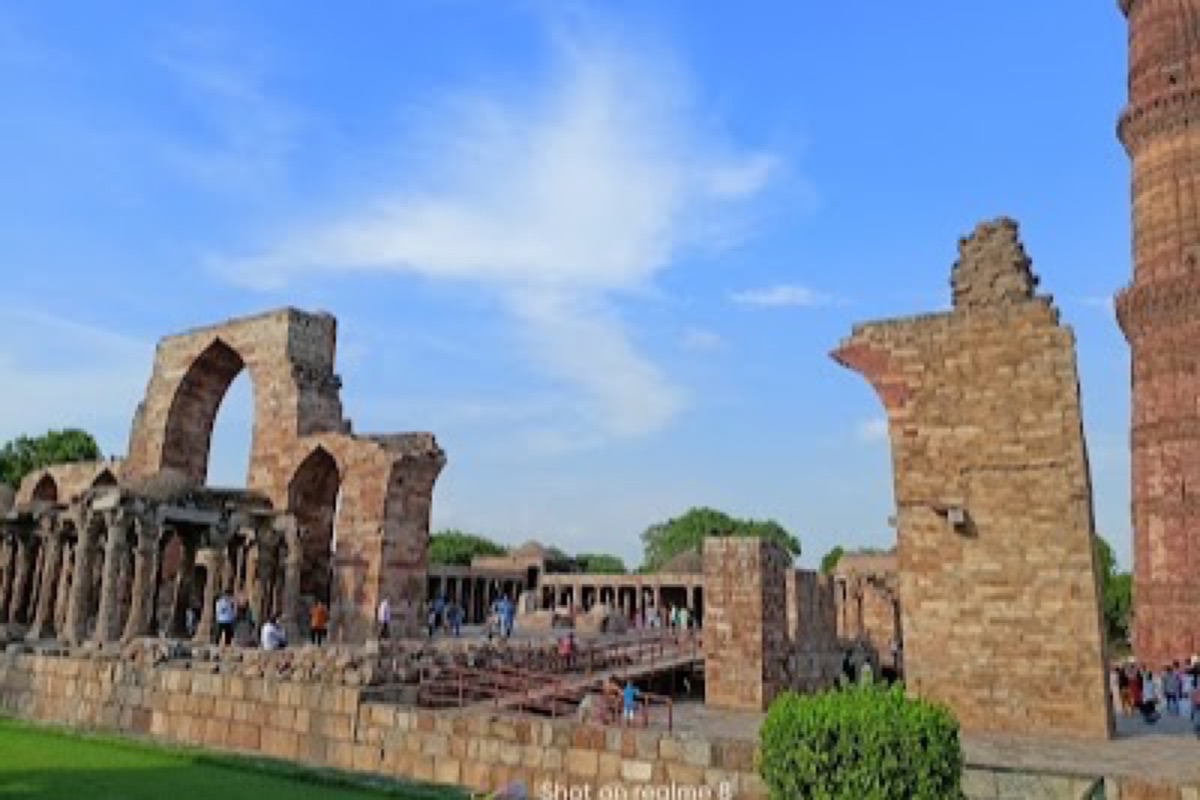 The carved sandstone tower of Qutub Minar rising above the surrounding ruins in Mehrauli
