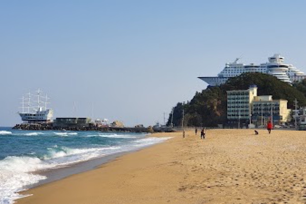 Jeongdongjin Beach sunrise over the East Sea with hourglass sculpture and sandy shore in Gangneung
