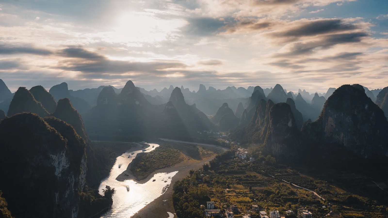 Li River winding between misty karst peaks near Xingping at golden hour