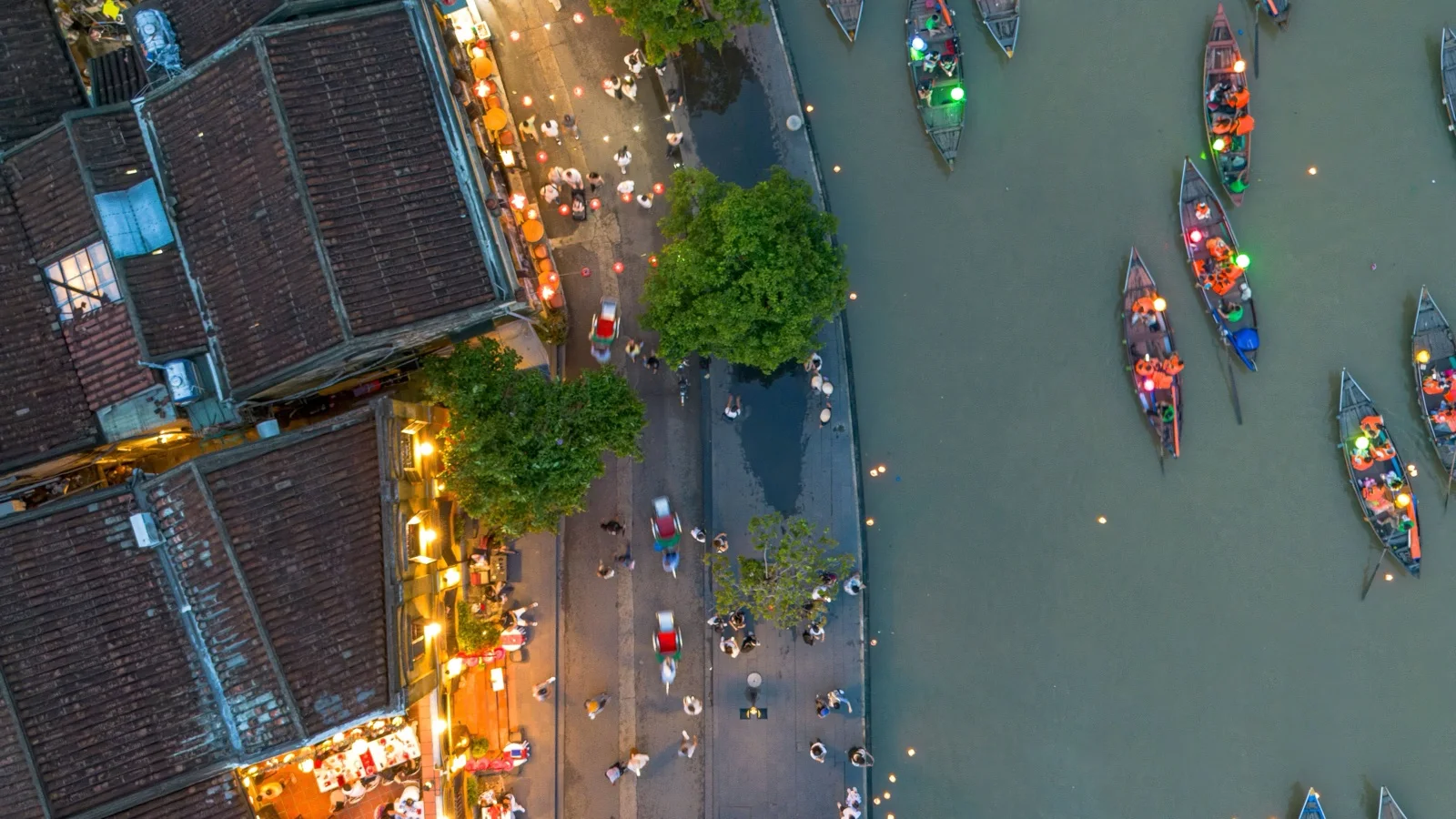 Silk lanterns and wooden boats along the Thu Bon River in Hoi An Ancient Town at dusk