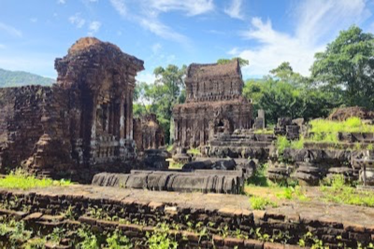 Cham brick towers of My Son Sanctuary rising from the jungle valley at sunrise