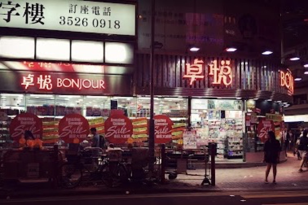 Temple Street Night Market neon signs glowing over food stalls and diners in Kowloon