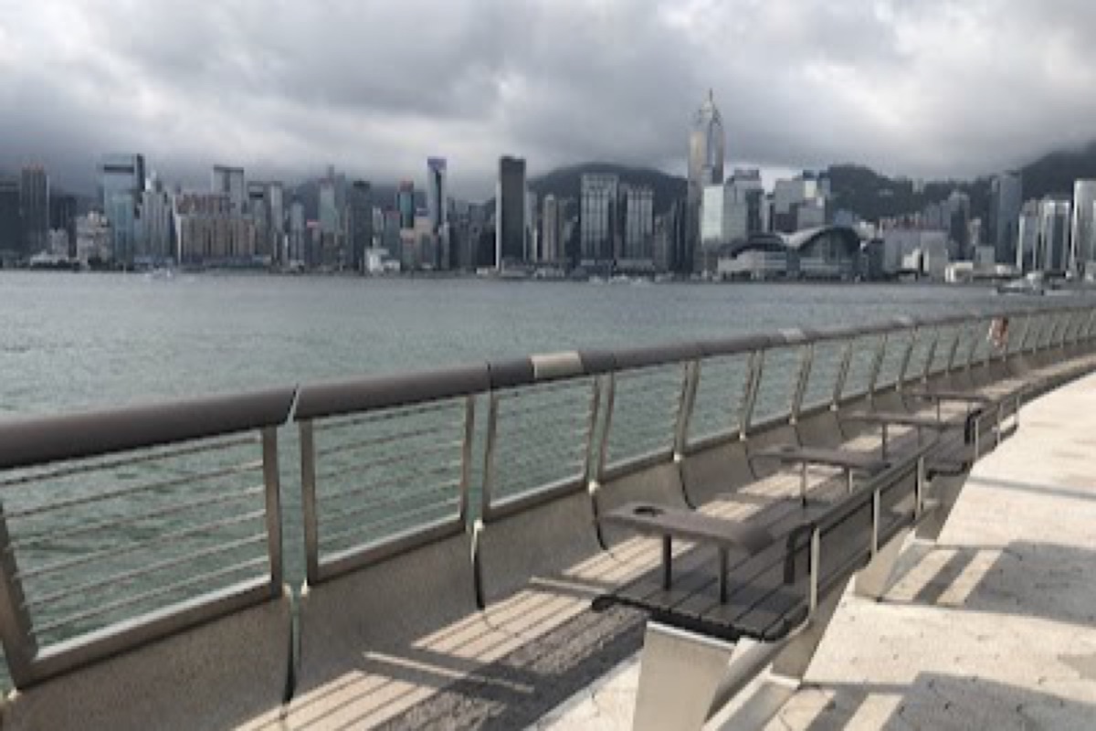 Tsim Sha Tsui Promenade harborfront walk with the Hong Kong Island skyline across the water