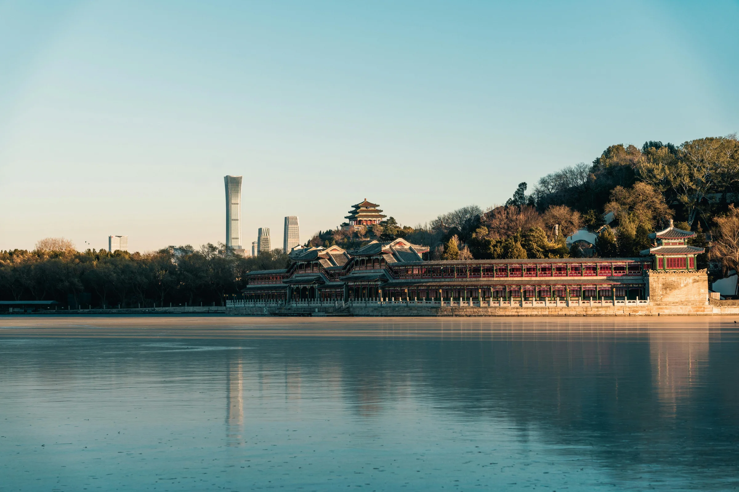 Wide hero view of Baotu Spring park with traditional pavilions, water, and surrounding Jinan city backdrop in China