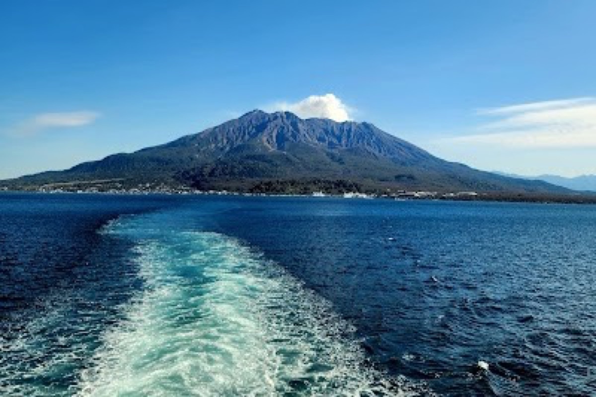 Sakurajima volcanic crater smoking above lava fields across Kinko Bay