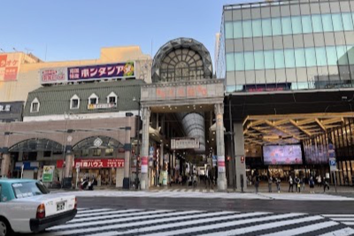 Tenmonkan covered arcade glowing with neon signs and izakaya lanterns at night in Kagoshima