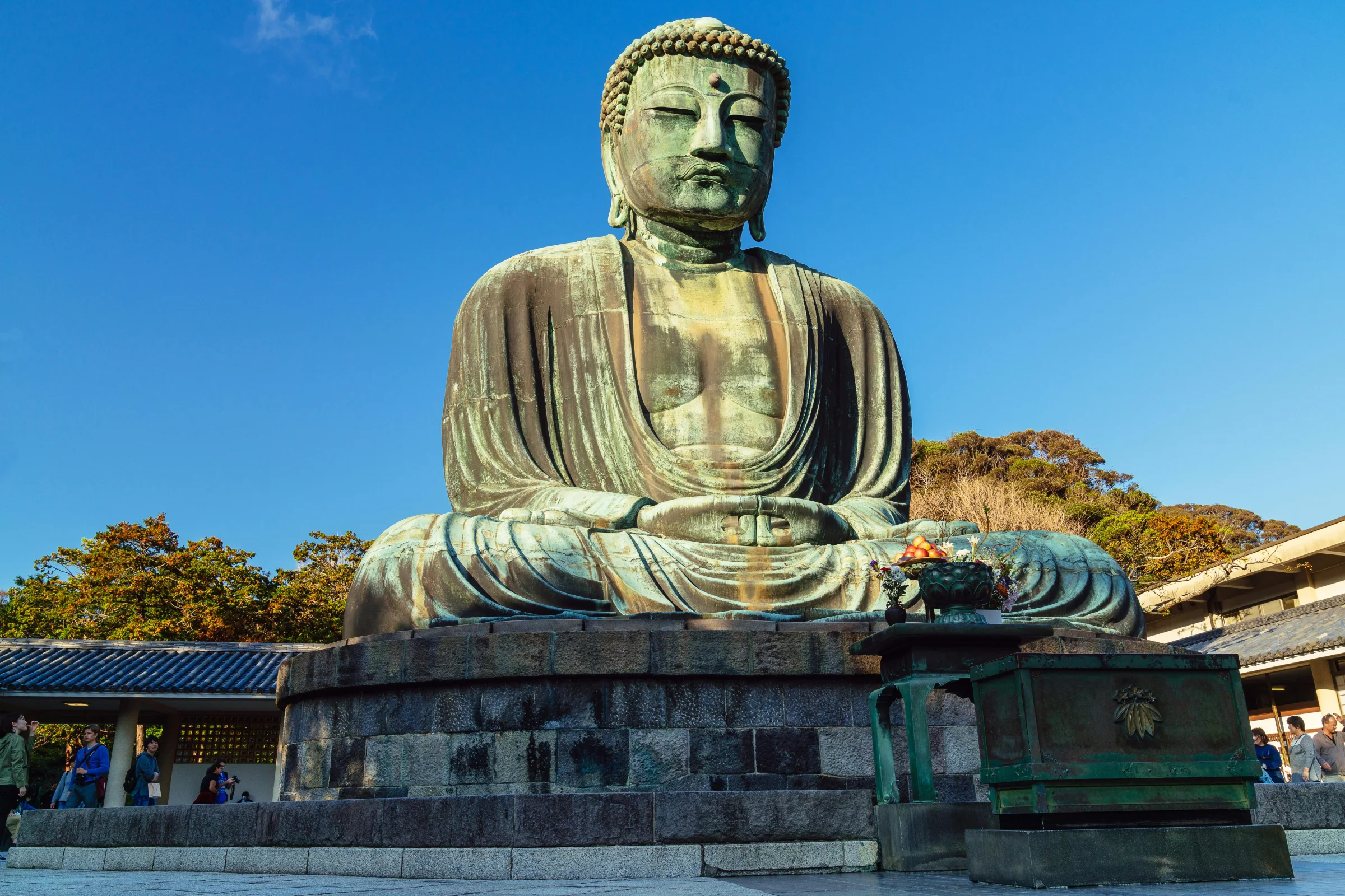 Hero image of Kamakura, Japan featuring the Great Buddha and a lively temple street scene.