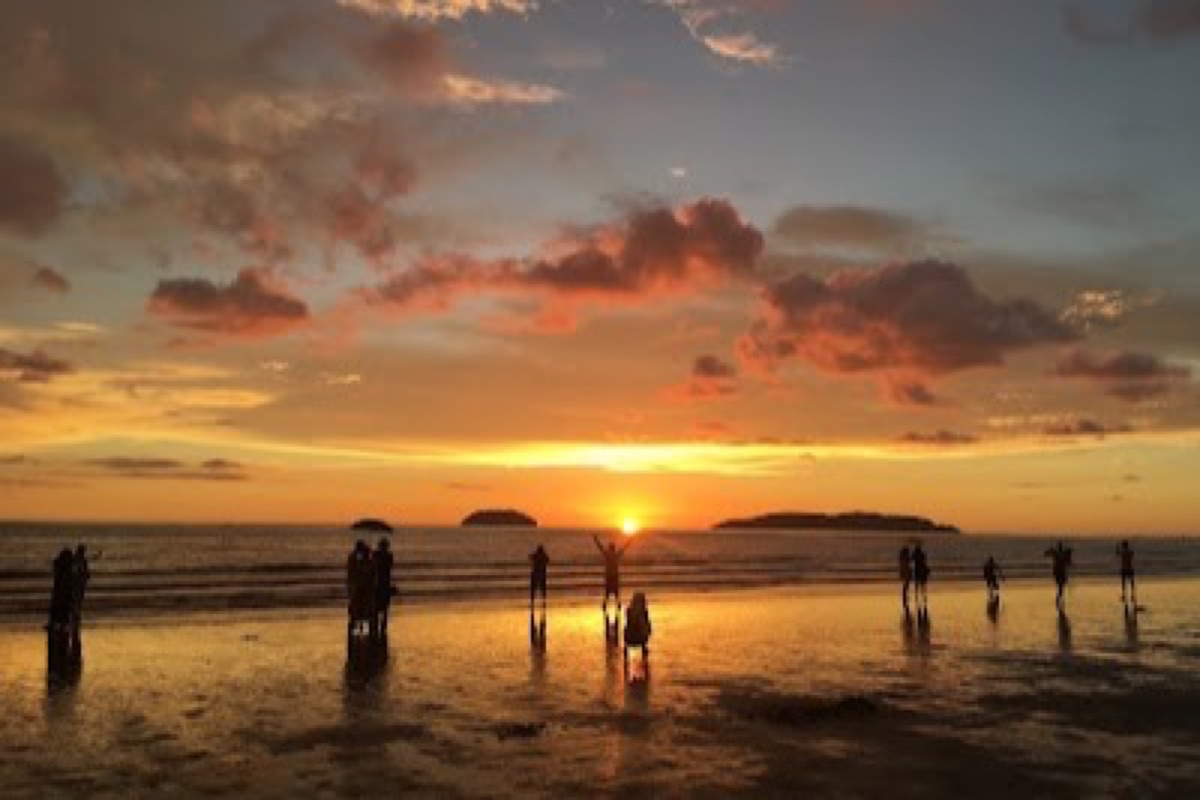 Golden sunset over the water and food stalls at Tanjung Aru Beach, Kota Kinabalu