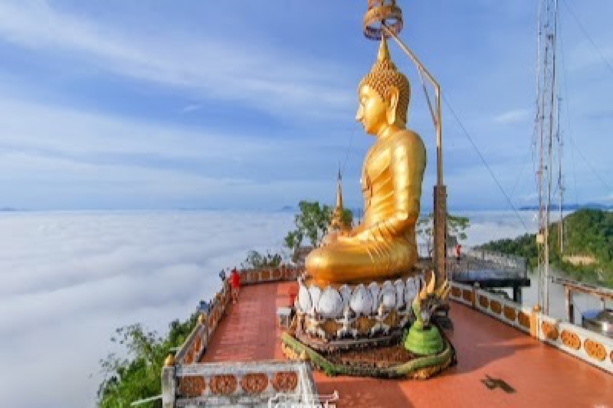 Golden Buddha and jungle panorama at the summit of Tiger Cave Temple above Krabi