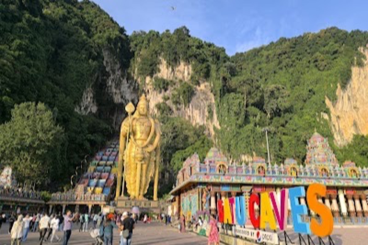 Golden Lord Murugan statue and rainbow steps leading up to Batu Caves temple