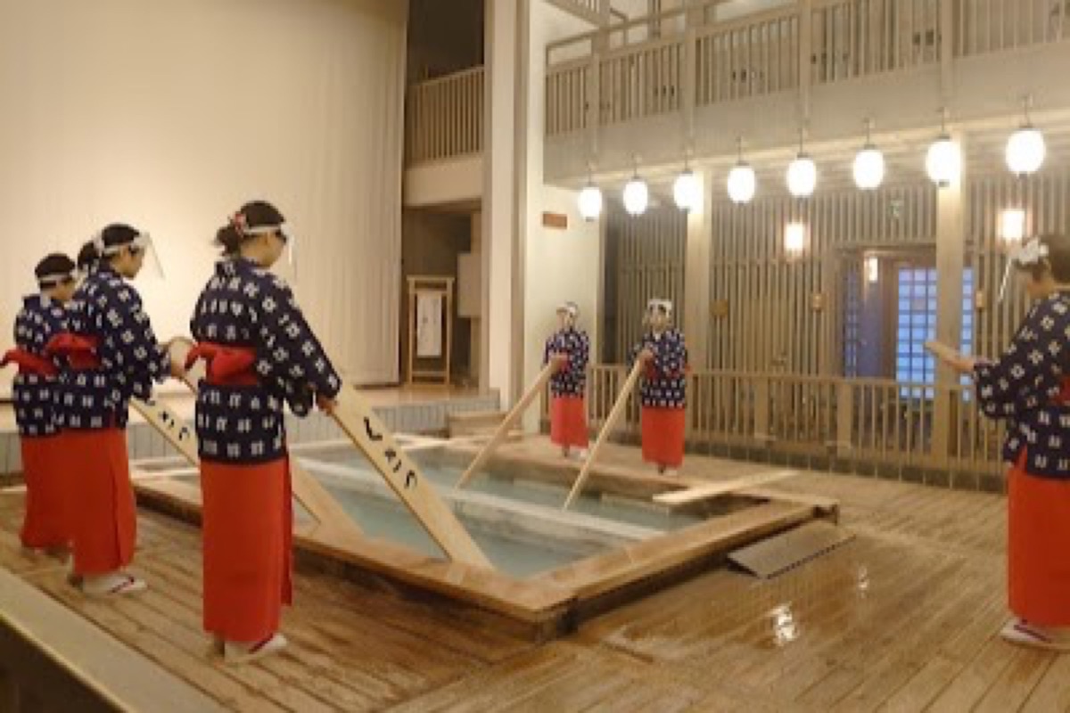 Netsunoyu Hall yumomi performers cooling onsen water with wooden paddles in Kusatsu