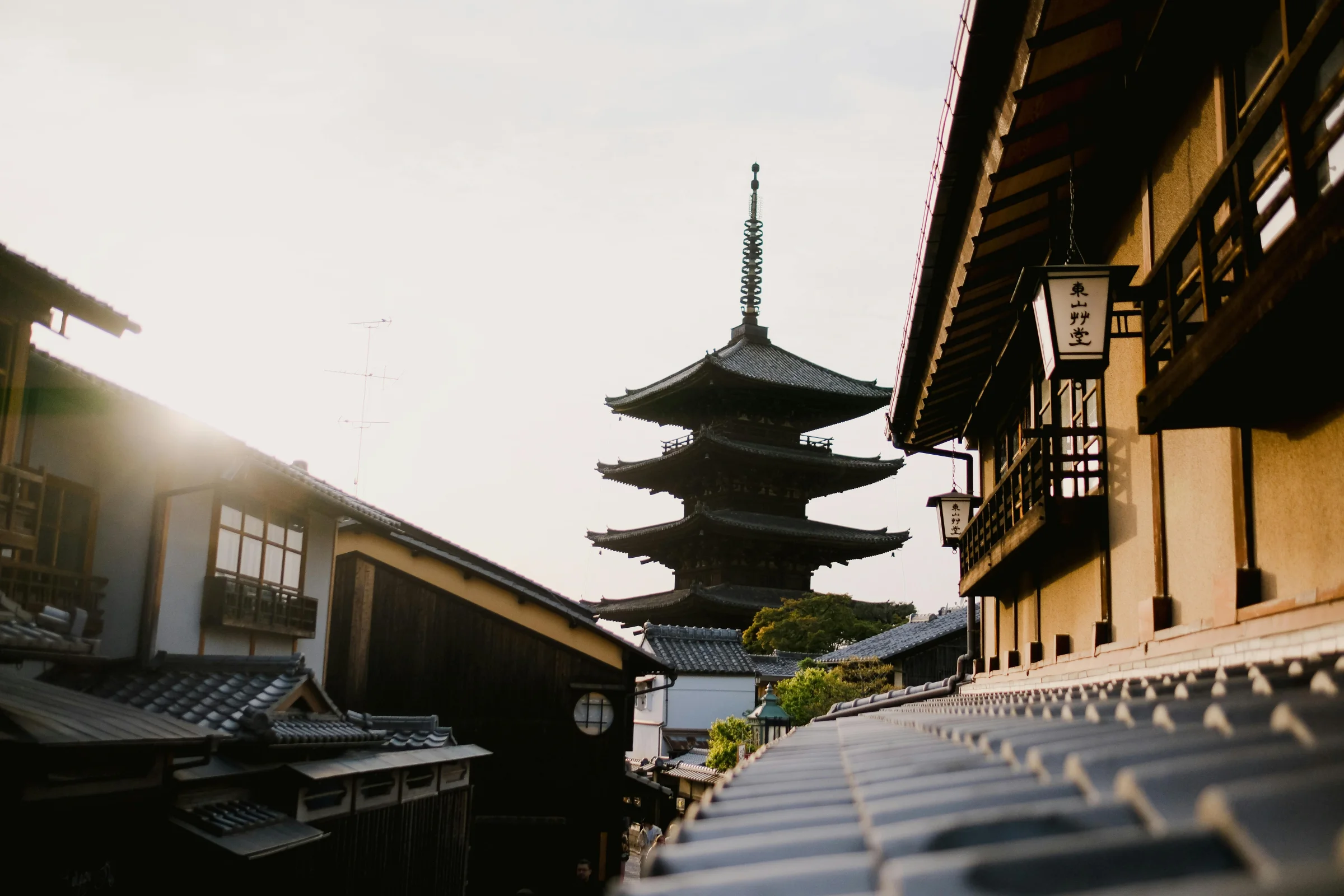 Sunset view of a traditional Kyoto street with a pagoda in the background