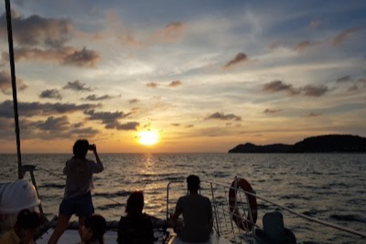 Catamaran sunset dinner cruise sailing past Langkawi's coastline on the Andaman Sea