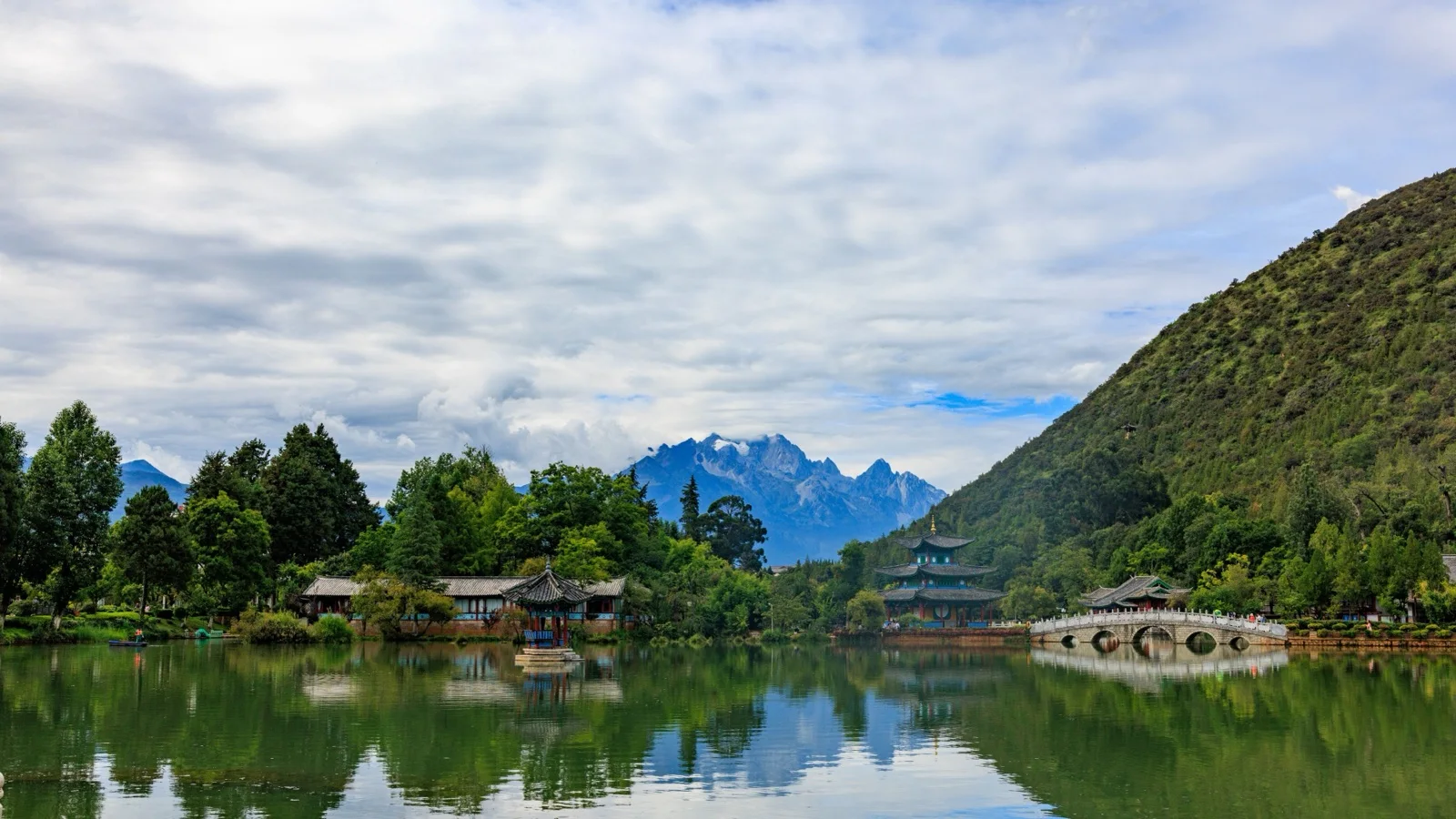 Morning view of Lijiang with Jade Dragon Snow Mountain rising above the gray-tile rooftops and canals of the old town