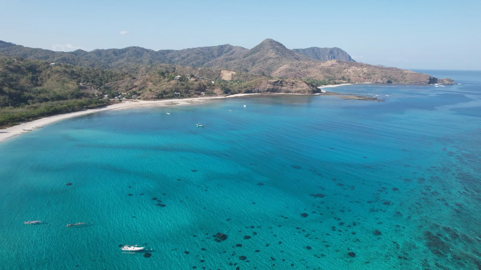 Rose-tinted sand and turquoise reef water at Pink Beach on Lombok's remote east coast