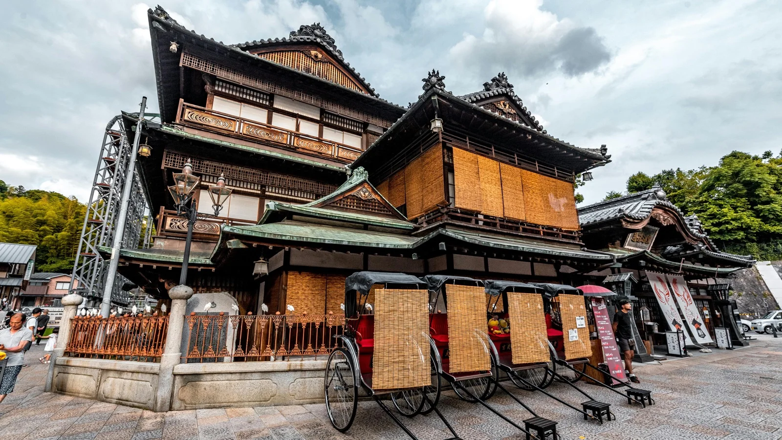 Dogo Onsen Honkan historic wooden bathhouse facade lit up at dusk in Matsuyama