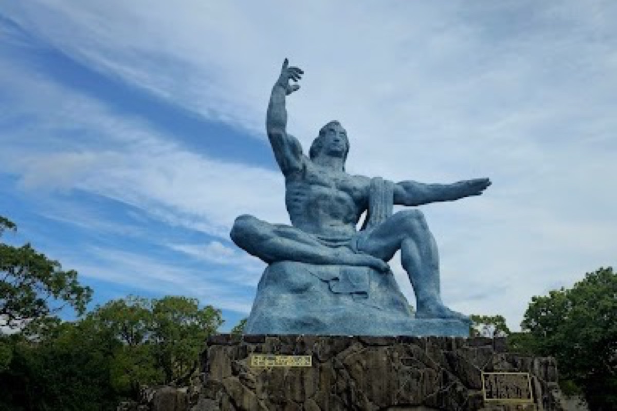 The bronze Peace Statue in Nagasaki Peace Memorial Park under spring sunlight