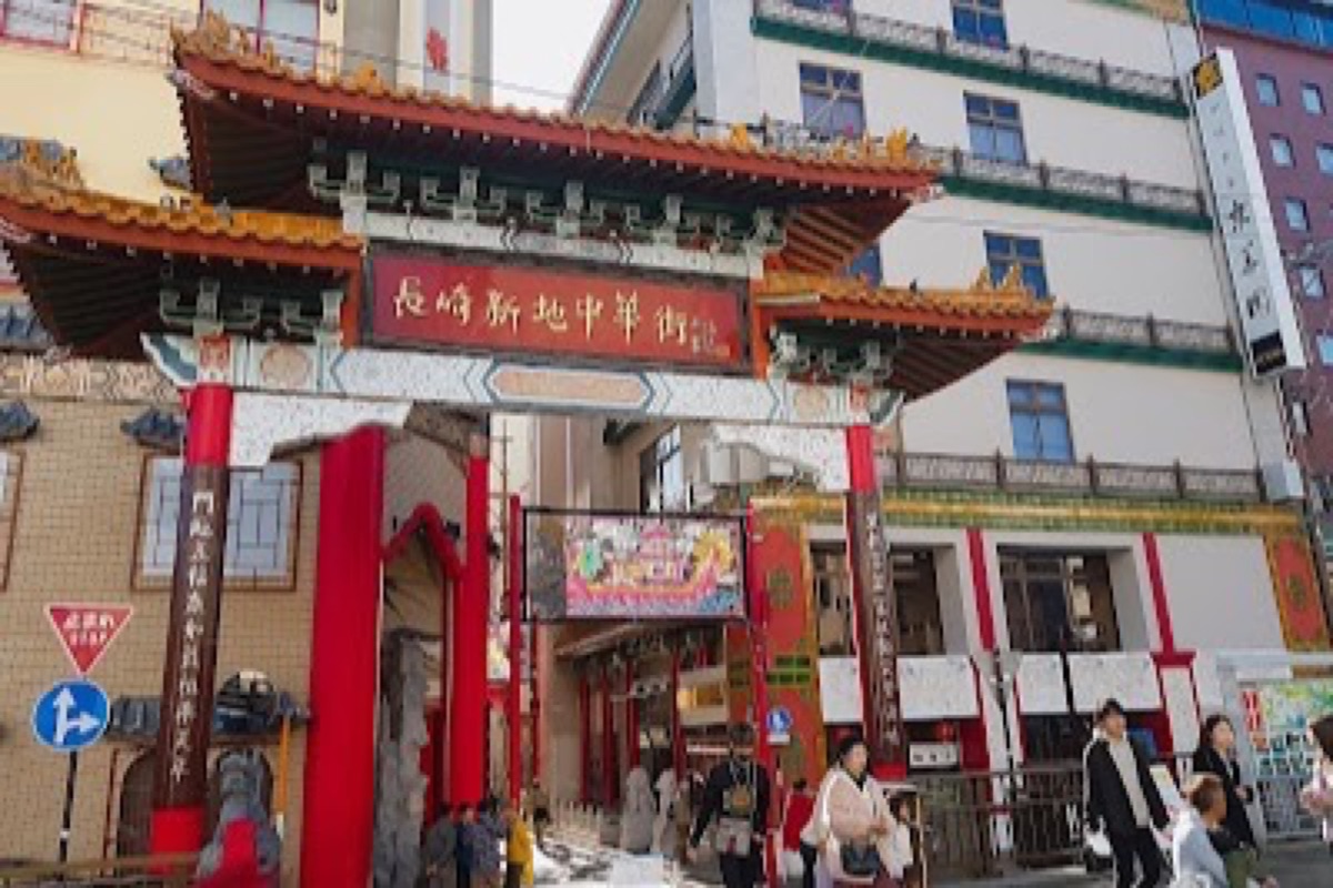 Colorful lanterns and restaurant entrances lining Shinchi Chinatown's main street in Nagasaki