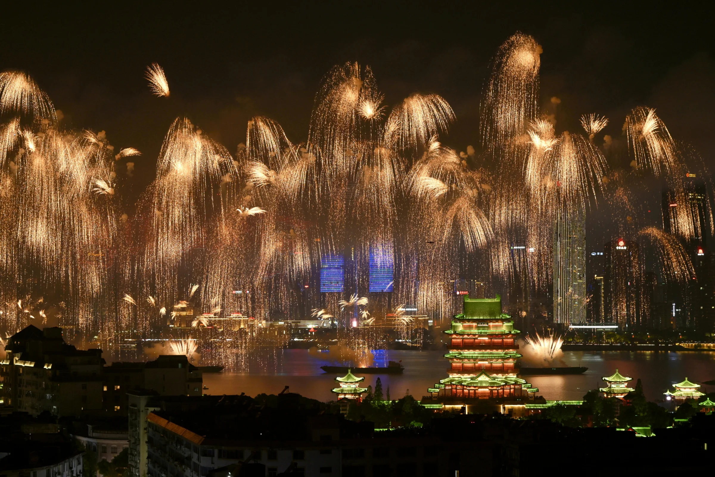 Nanchang skyline along the Gan River at dusk with city lights reflecting on the water