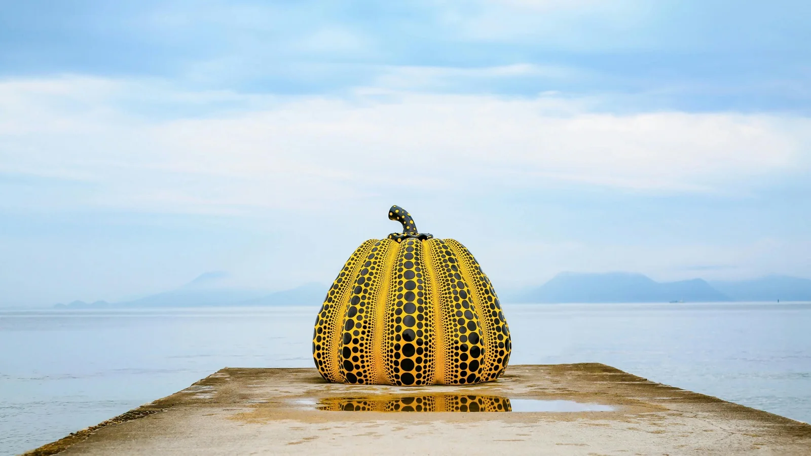 Yellow Pumpkin sculpture on the Naoshima coast with the Seto Inland Sea beyond