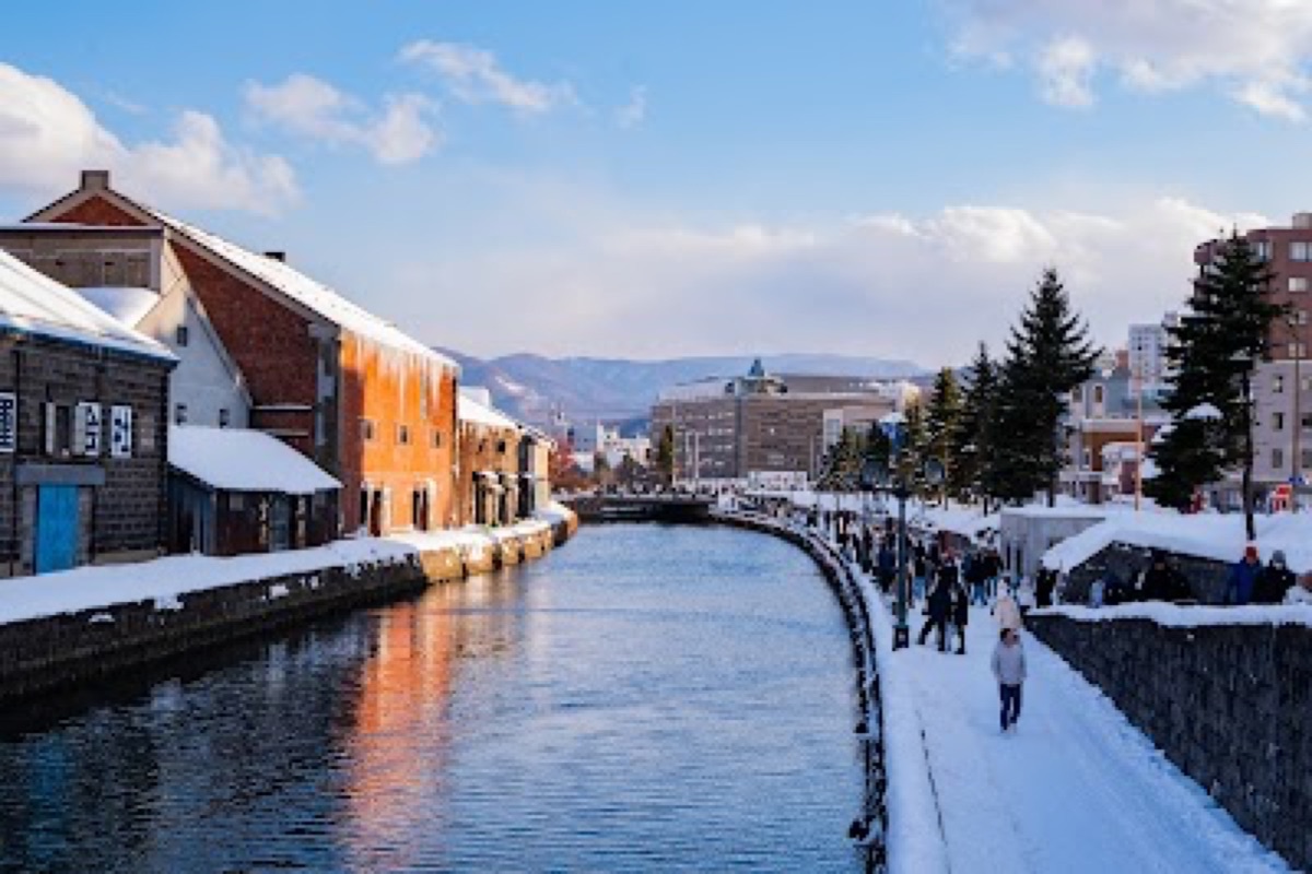 Otaru Canal stone arches and gas lamps reflecting on the water at golden hour