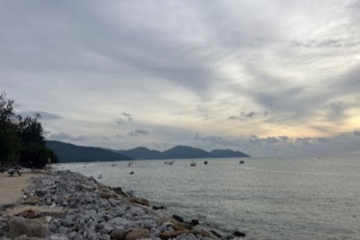 Batu Ferringhi beach at sunset with the night market strip along Penang's north coast