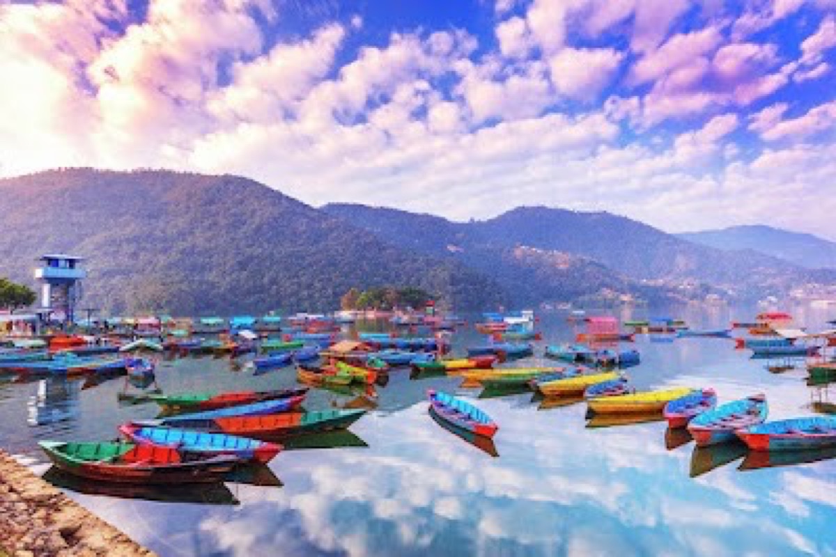 Colorful doonga rowboats on Phewa Lake with the Annapurna range beyond