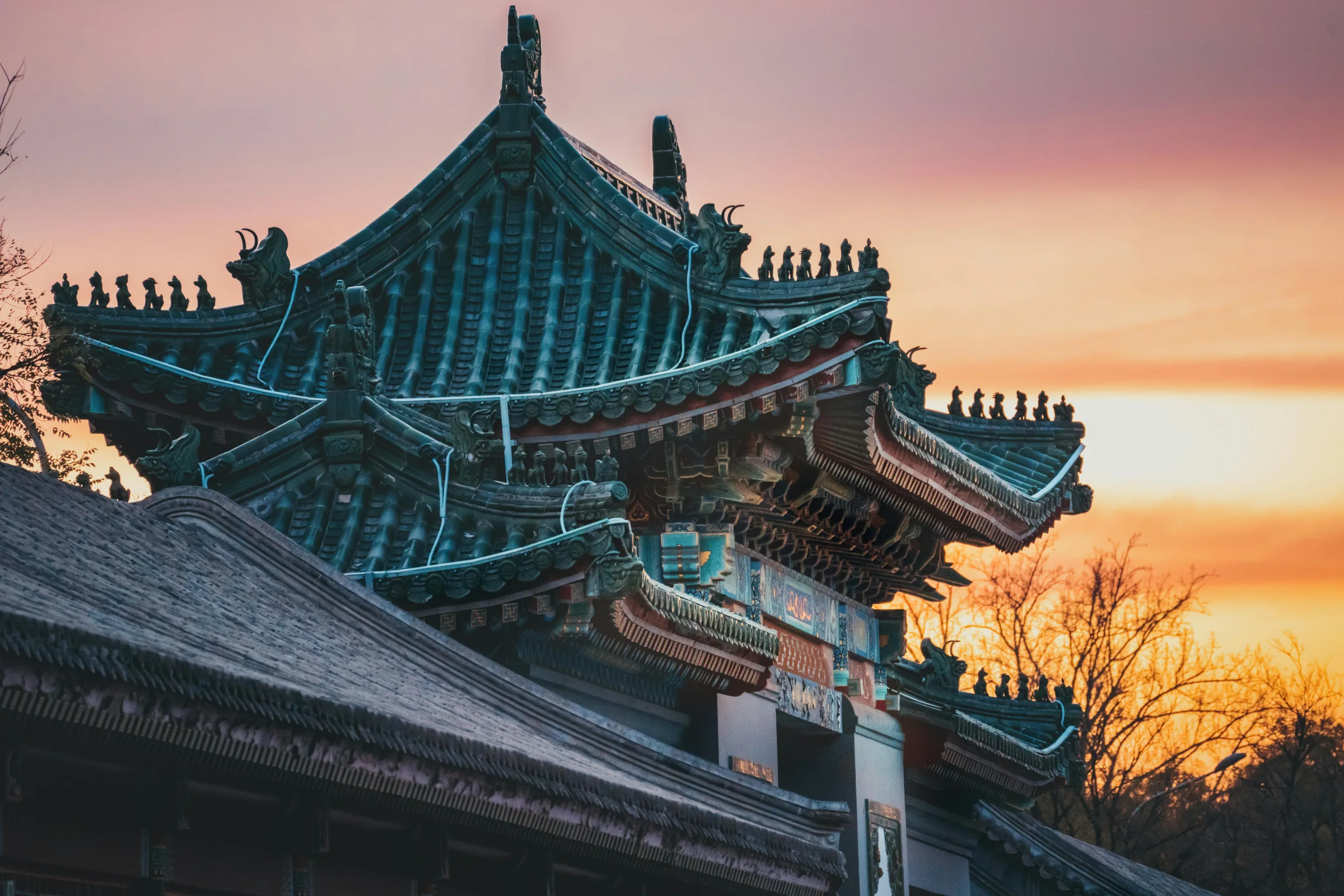 Warm sunset view of a historic street in Quanzhou, China with traditional architecture and temple rooftops.