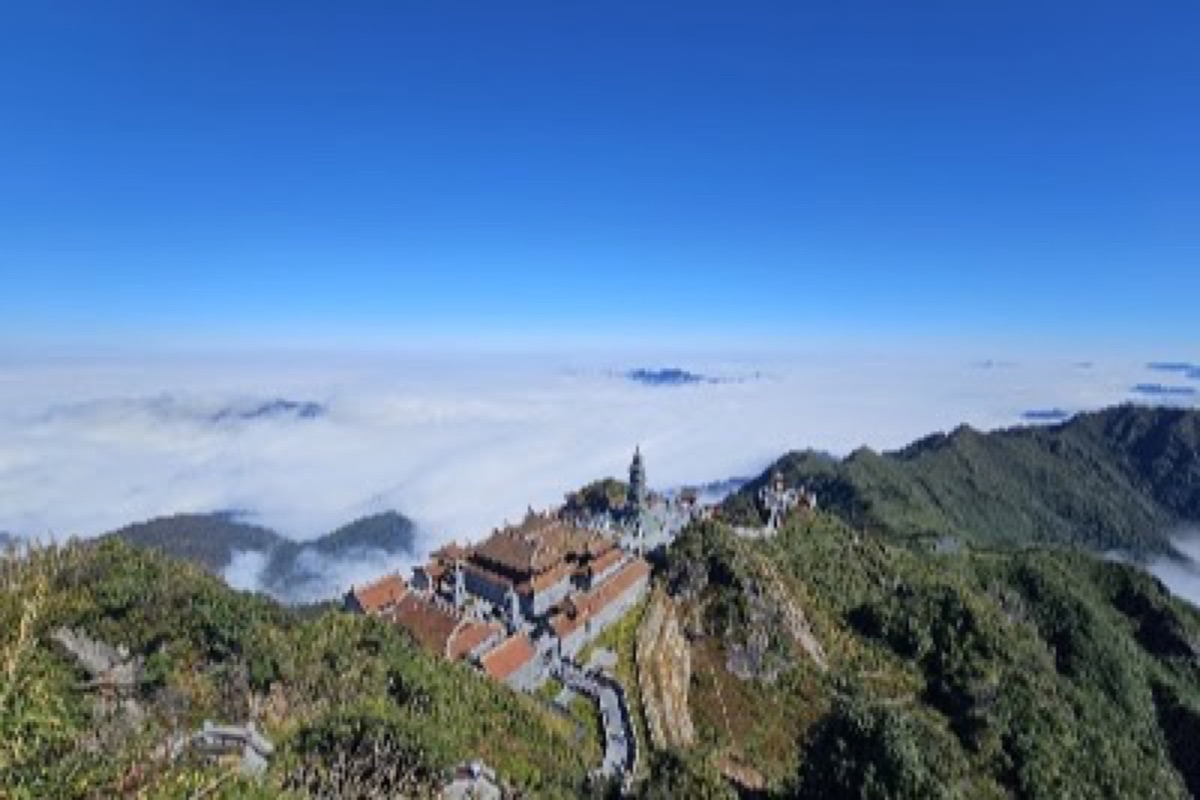 Summit temples and the giant Buddha statue rising above a sea of clouds on Fansipan
