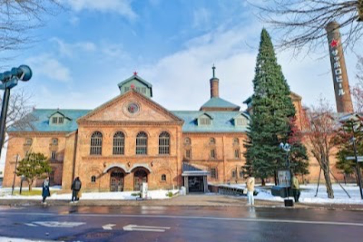 Historic red-brick Sapporo Beer Museum building with snow-dusted grounds