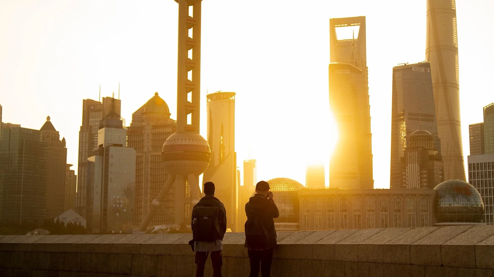 The Bund waterfront in Shanghai with the Pudong skyline lit up across the Huangpu River at dusk