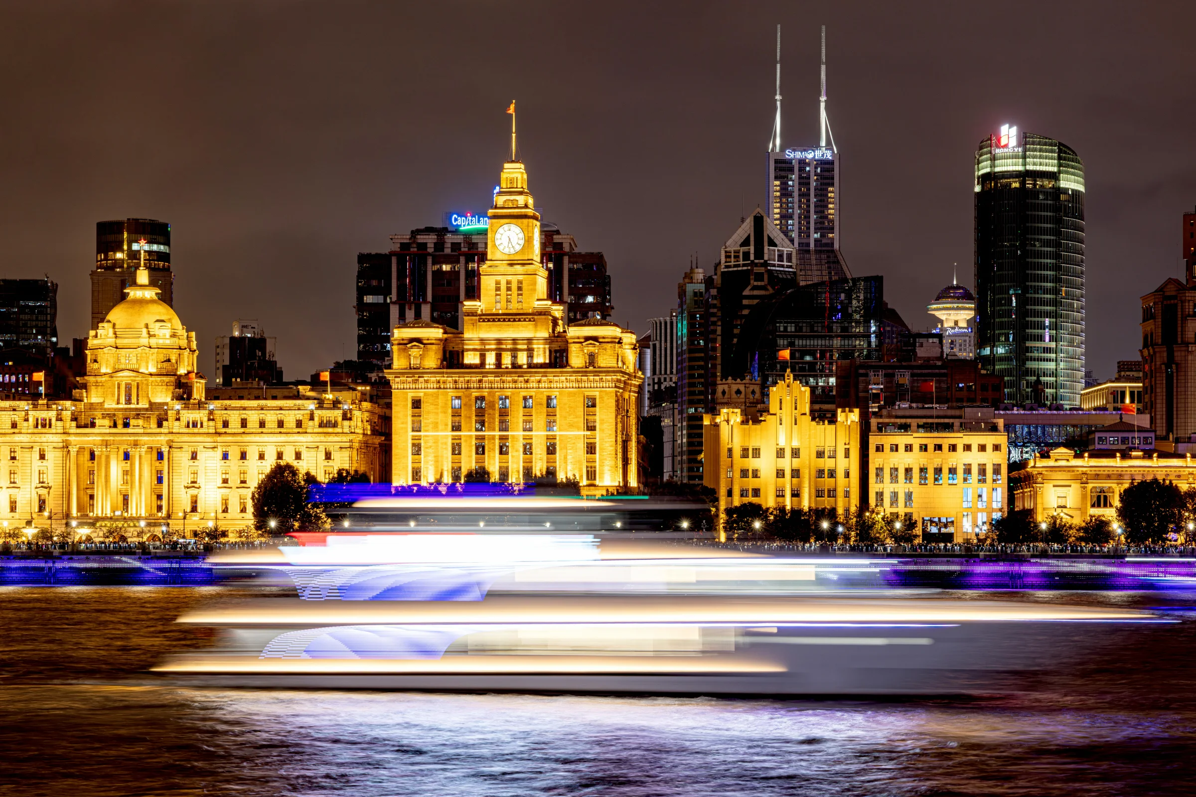 Shanghai skyline at night along The Bund waterfront with illuminated buildings