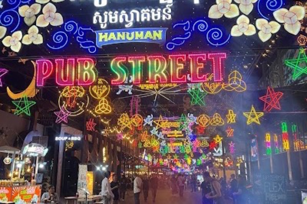 Neon signs and street food stalls along Pub Street at night in Siem Reap