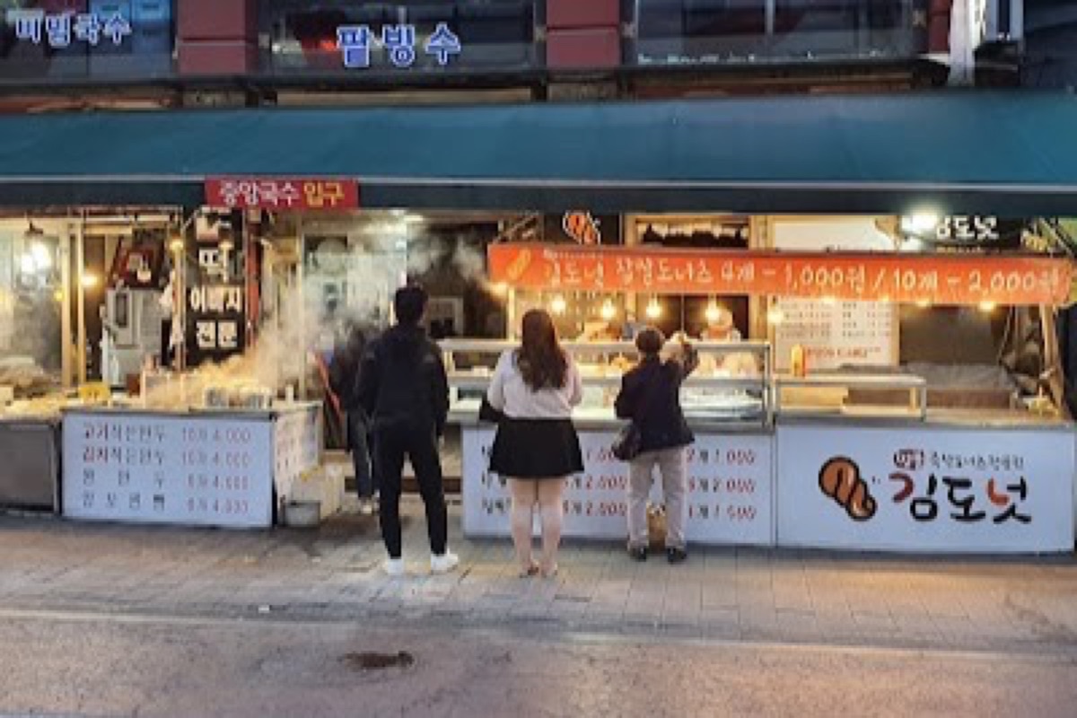 Paldalmun Market street food stalls serving hotteok and twigim beside the south gate in Suwon
