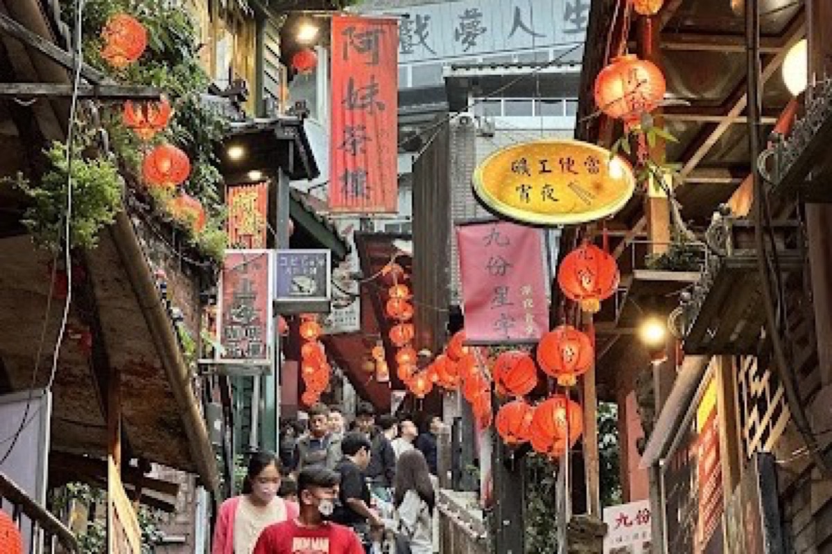 Jiufen Old Street red lanterns lining steep hillside lanes with ocean vistas in the background