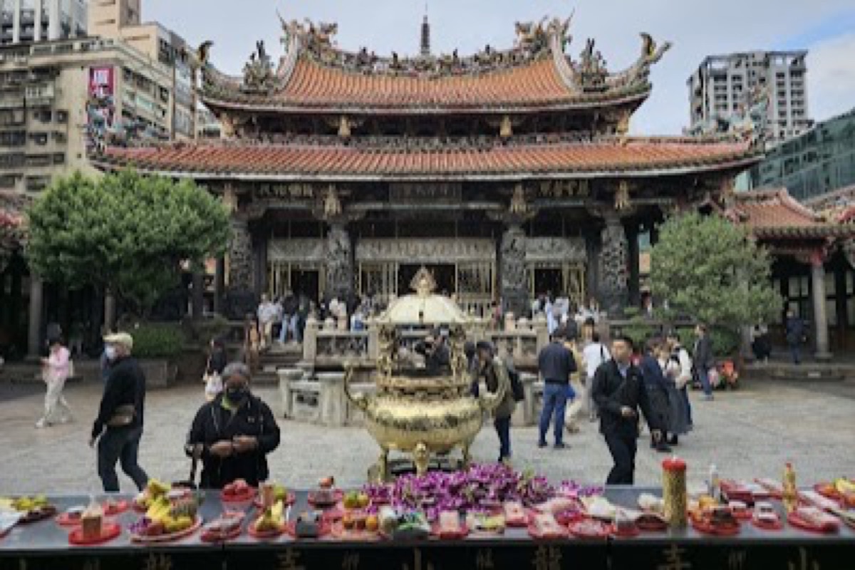 Longshan Temple ornate roof details and incense coils above the entrance in Wanhua District