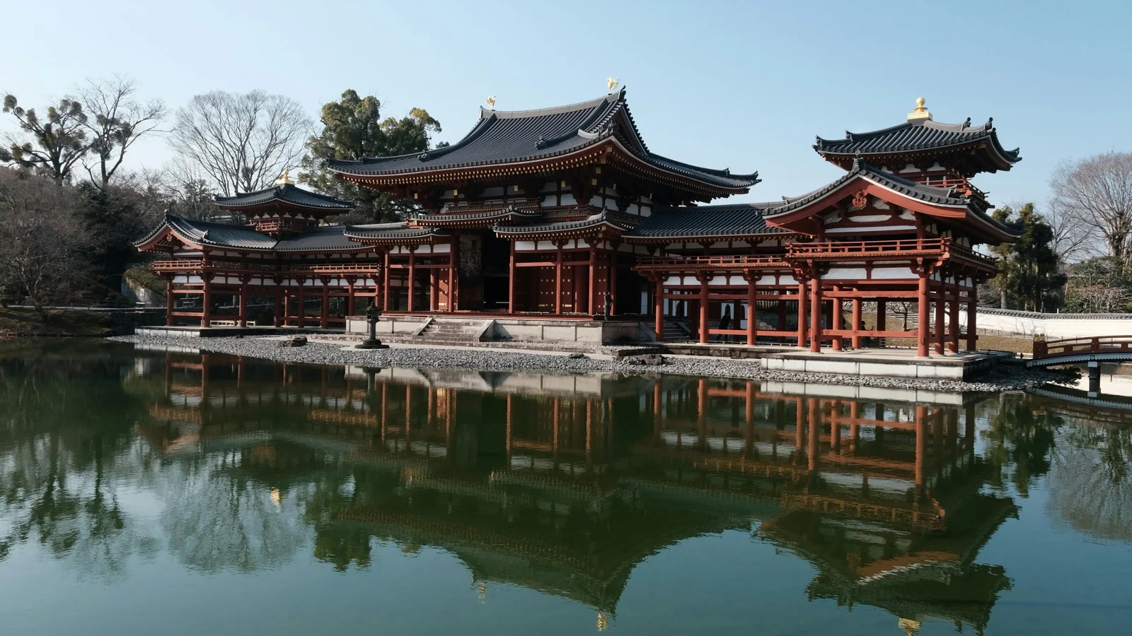 Byodoin Phoenix Hall reflected in the mirror pond with autumn maple trees in Uji