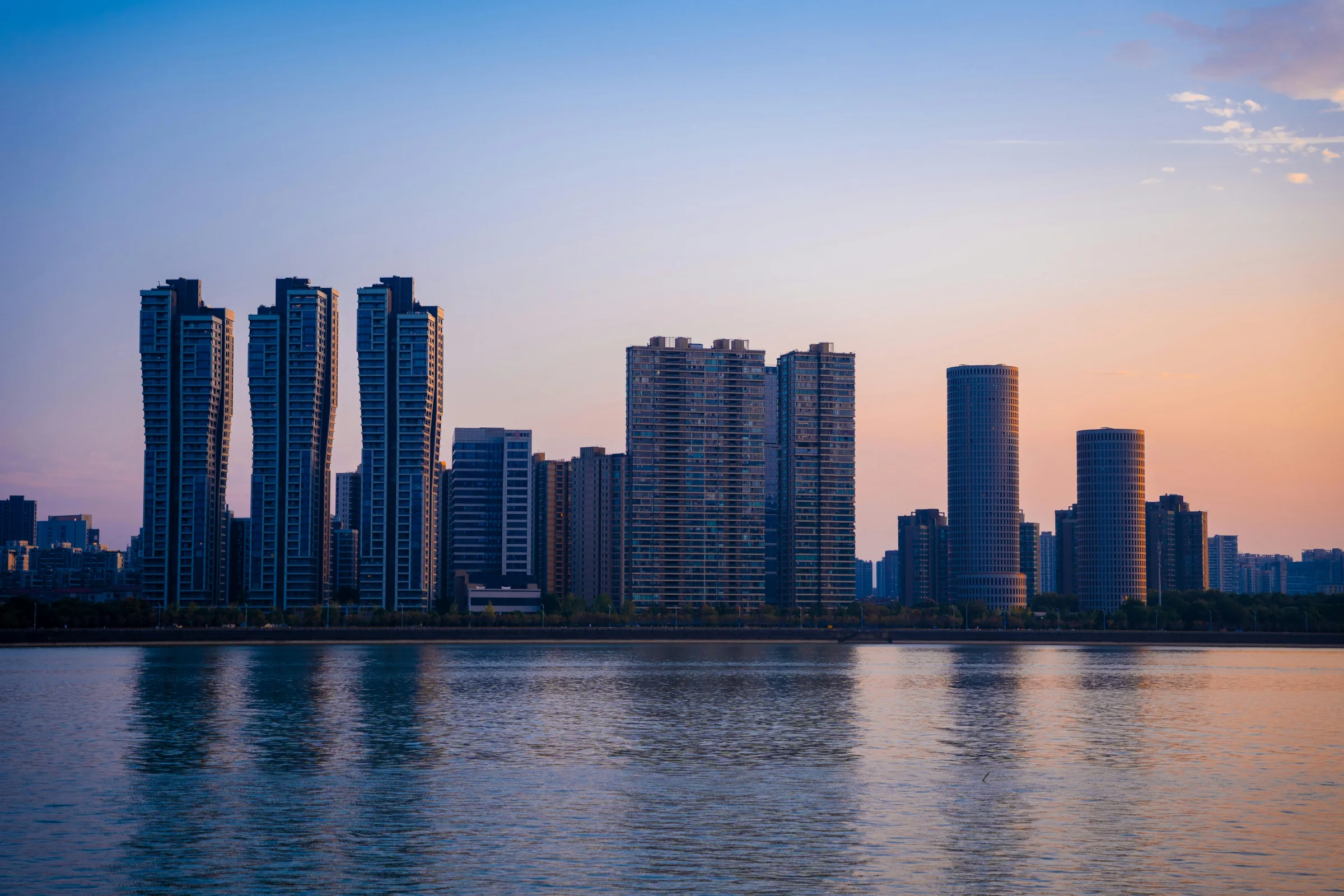Sunset view of Wuxi city skyline with a canal in the foreground