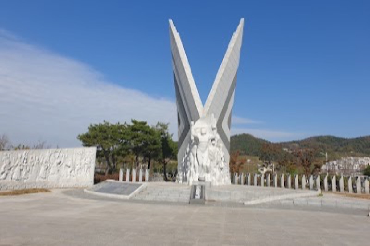 Yi Sun Shin Park replica turtle ship on the Yeosu harbor waterfront with coastal mountain backdrop